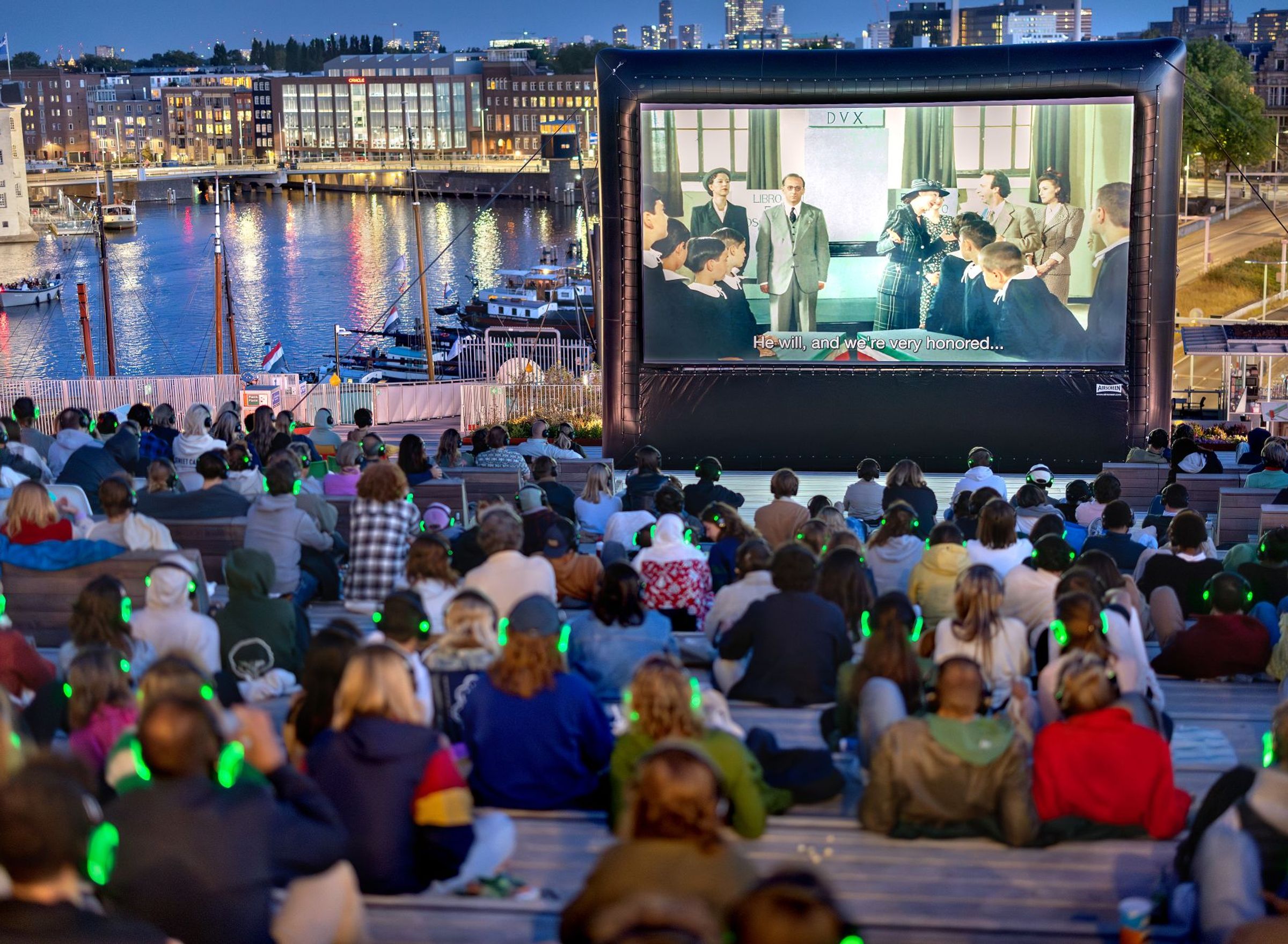 publiek kijkt bij zonsondergang naar groot filmscherm op het dak van NEMO