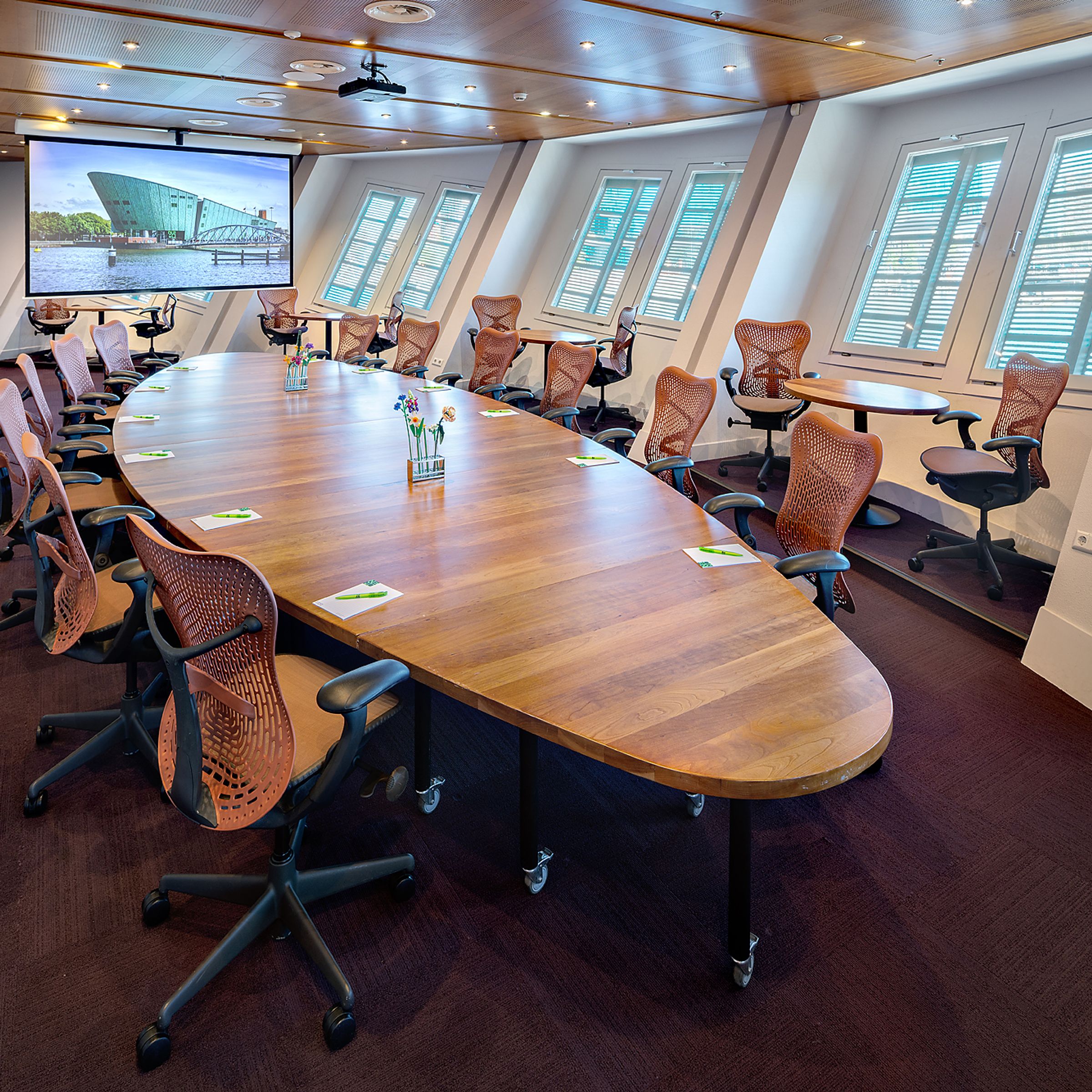 Lege vergaderzaal met houten tafel en bureaustoelen