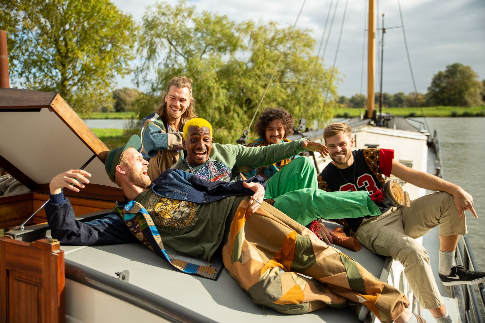 vijf blije jongens op een boot