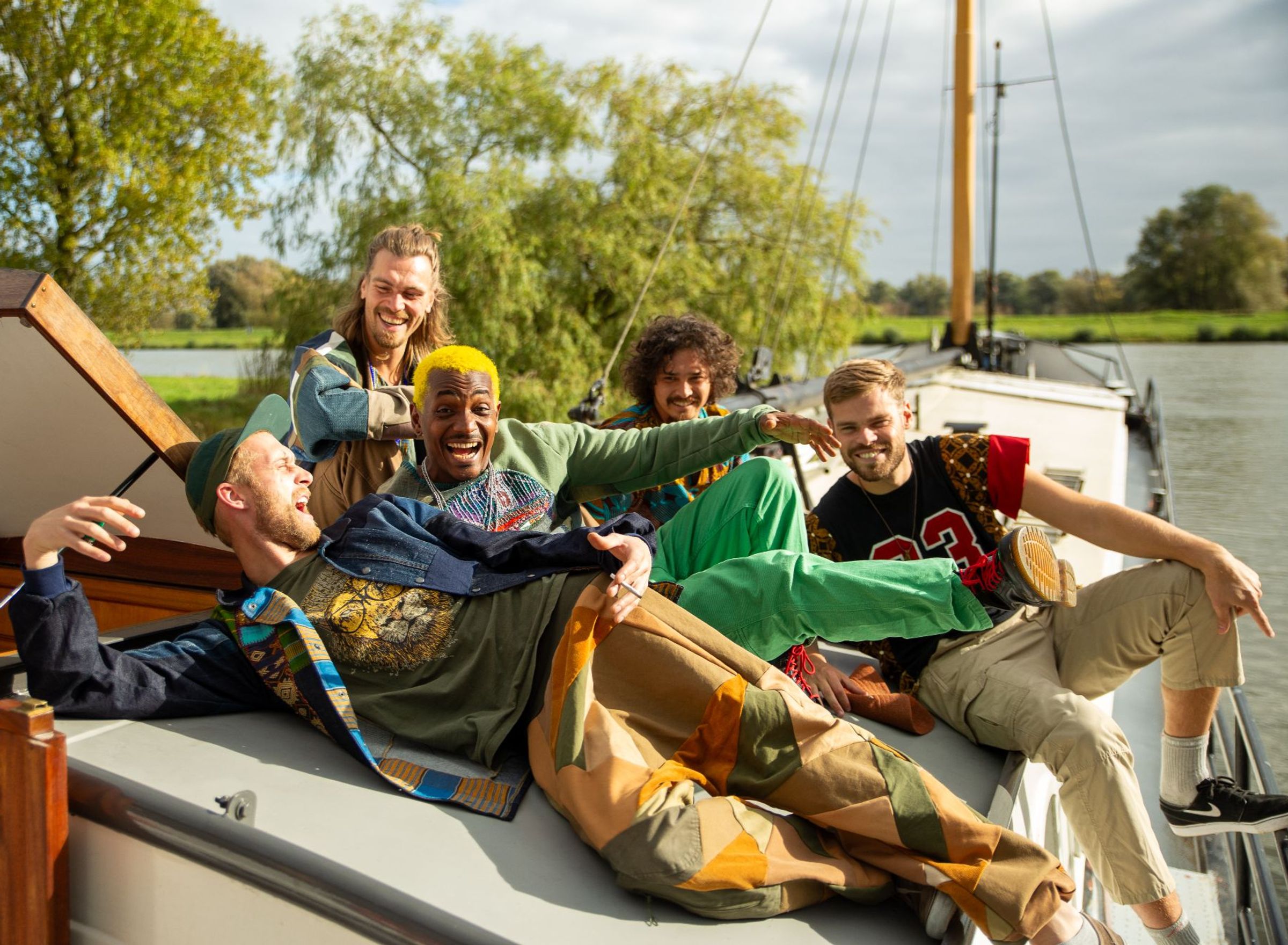 vijf blije jongens op een boot