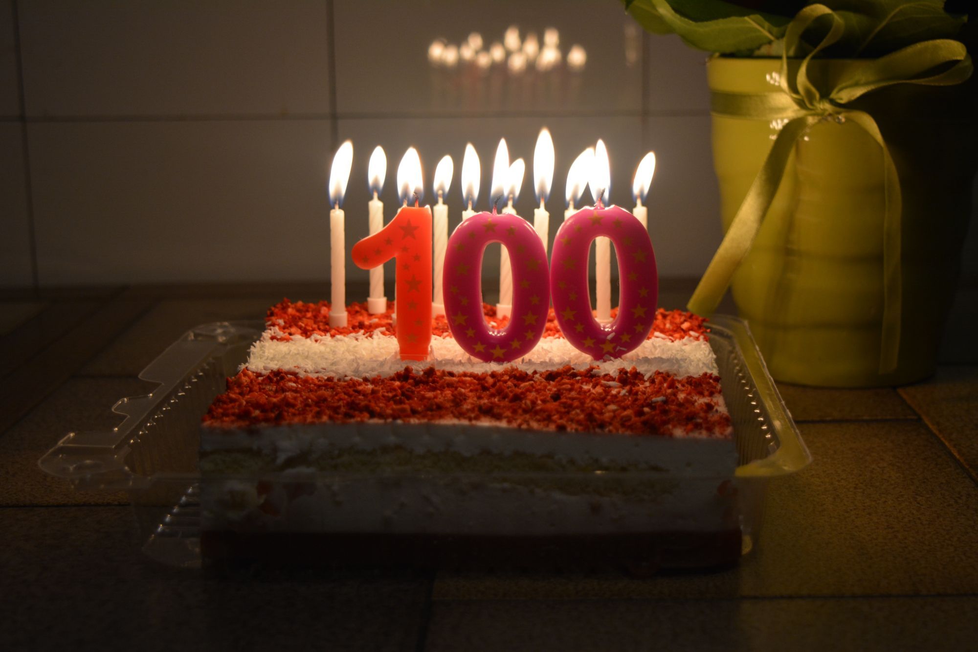 A cake with candles and the number 100.