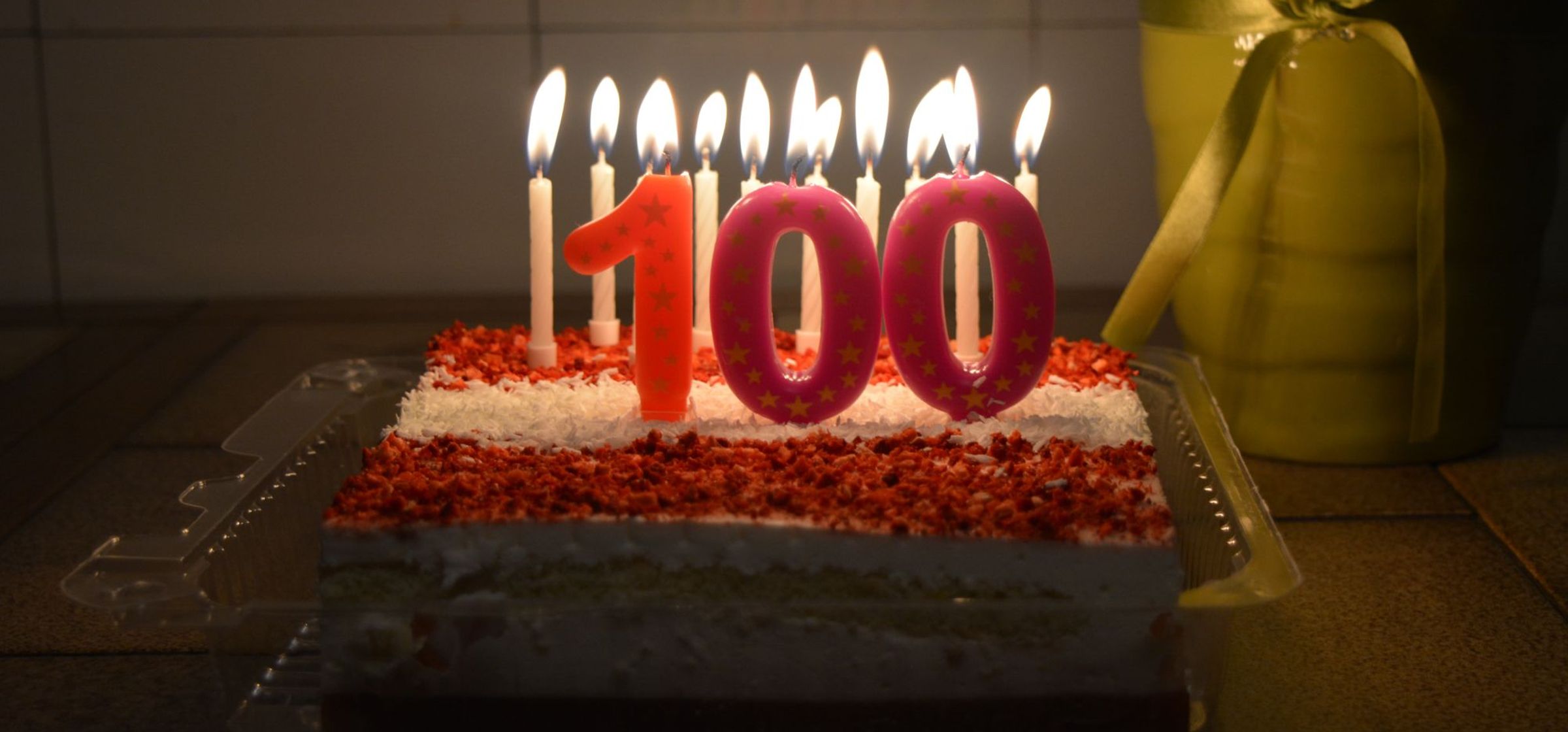 A cake with candles and the number 100.