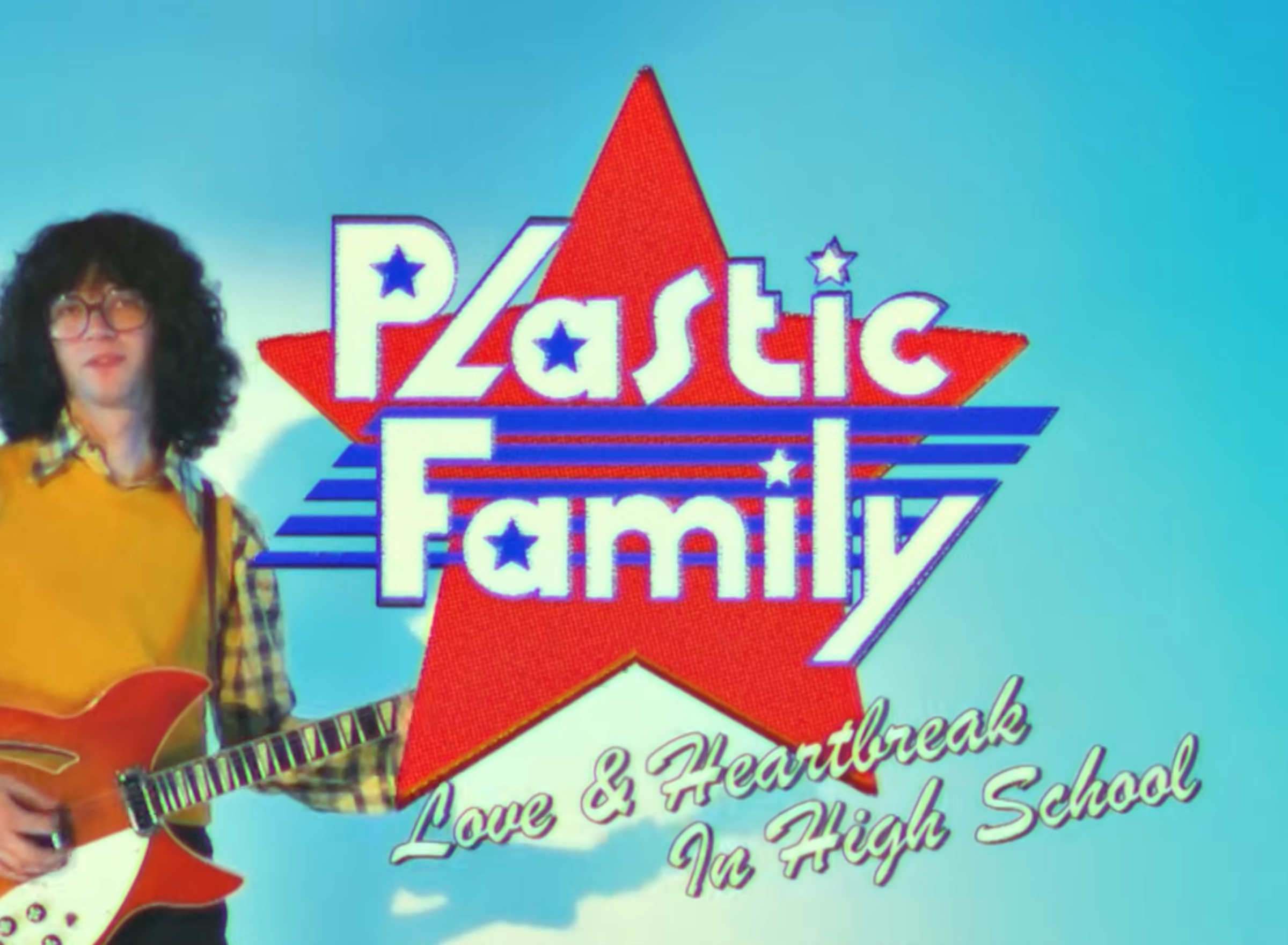 Een jongen met krullen op gitaar met daarnaast groot in beeld "Plastic Family, Live & Heartbreak in High School"