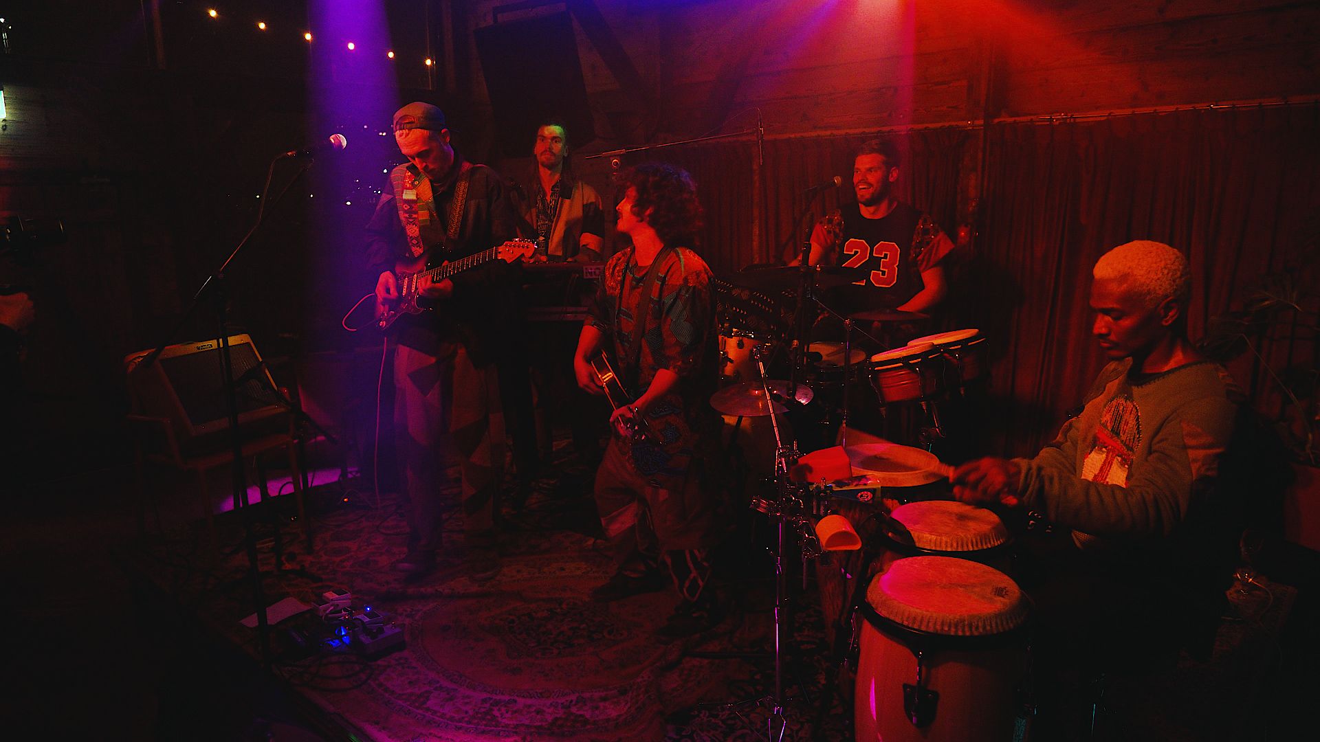 een band speelt in paars en rood licht