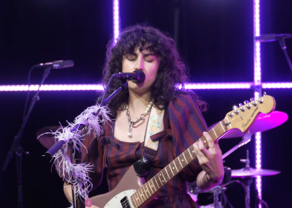 een meisje speelt gitaar en zingt