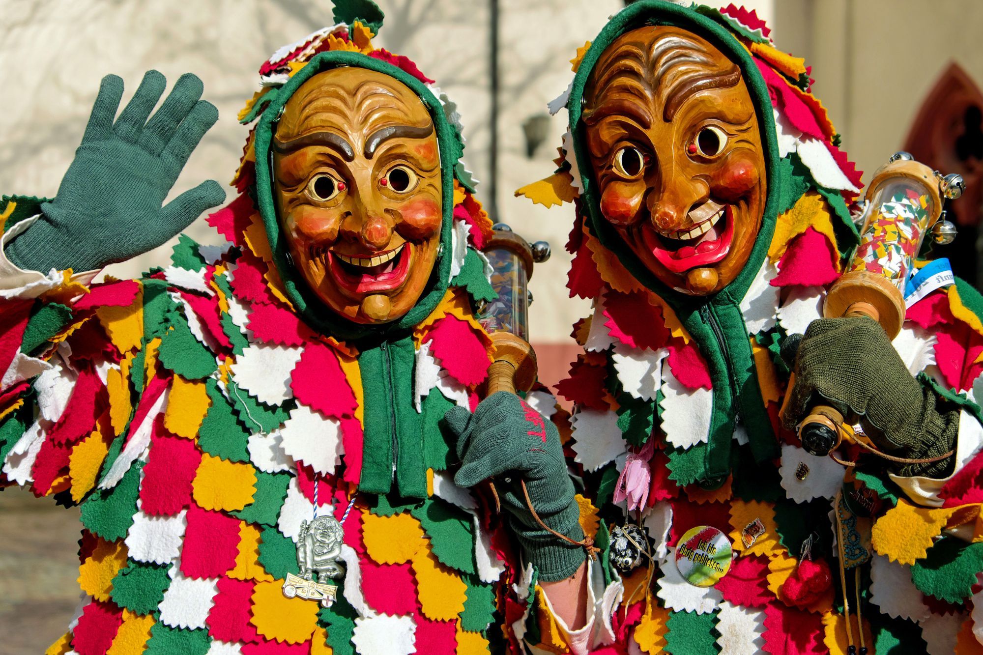 Two people wearing carnival masks.