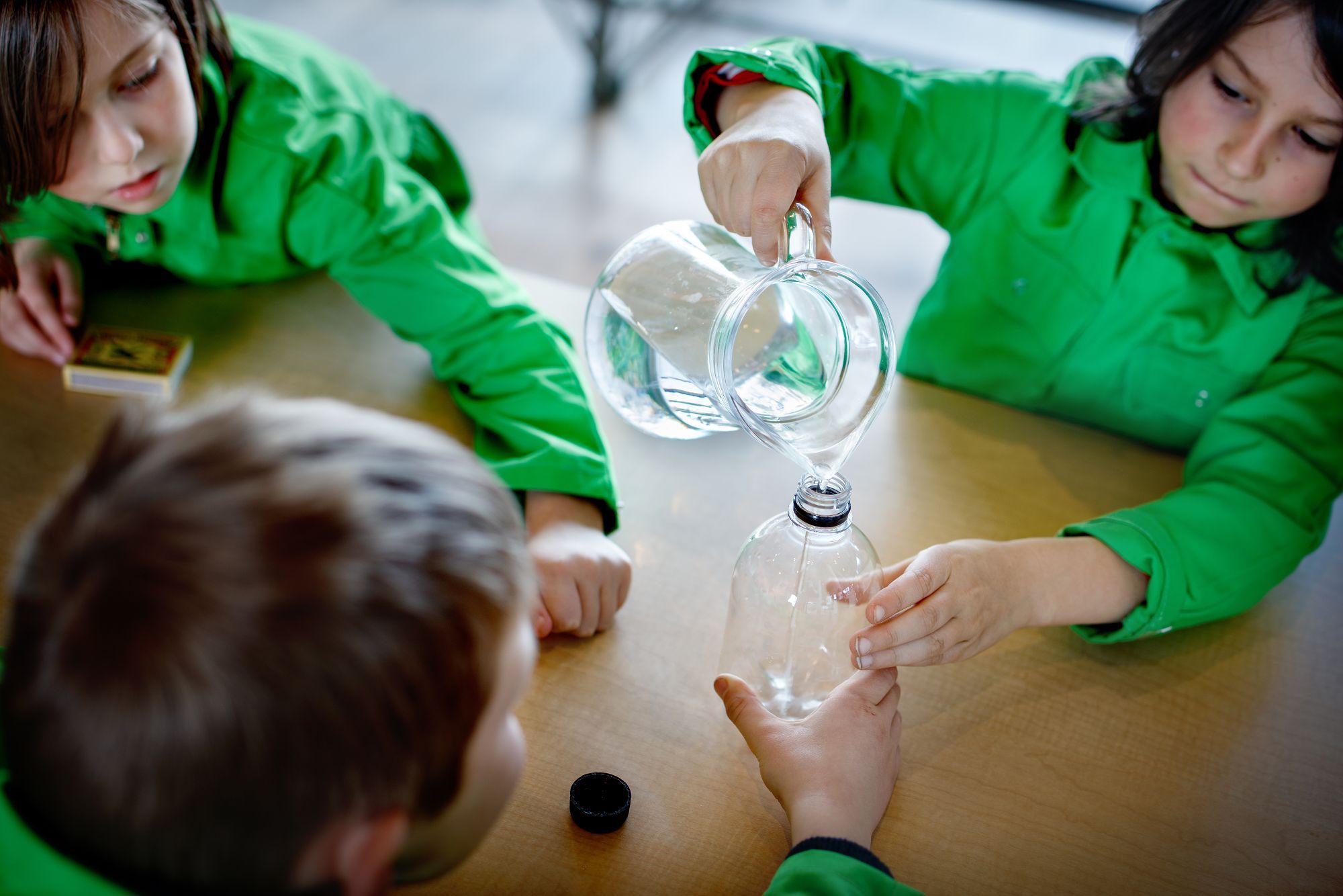 kinderen schenken water in een fles