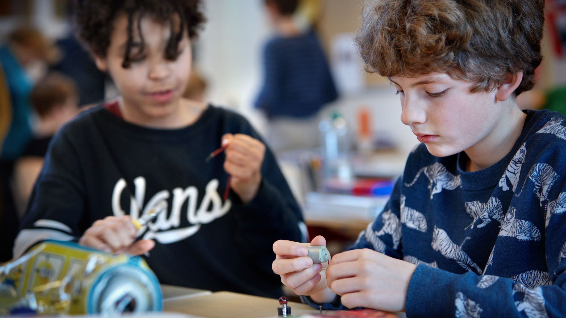 Twee jongens zijn bezig met elektriciteit draden.