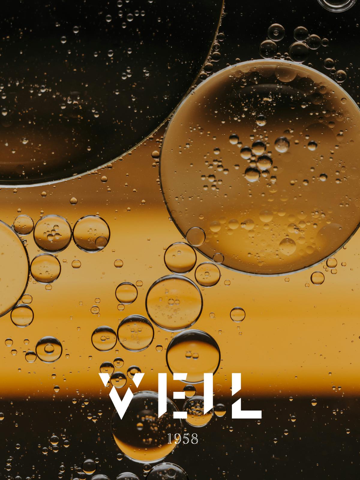 Macro photograph of golden oil bubbles suspended in liquid.