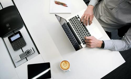 antreprenor lucrând la laptop și pregătind un nou contract comercial