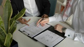 two people signing documents