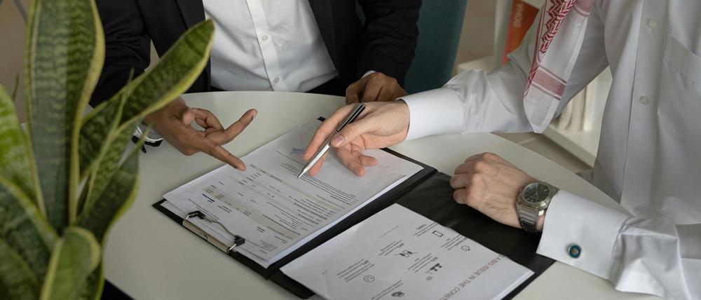 two people signing documents