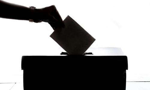 hand introducing a vote into a ballot