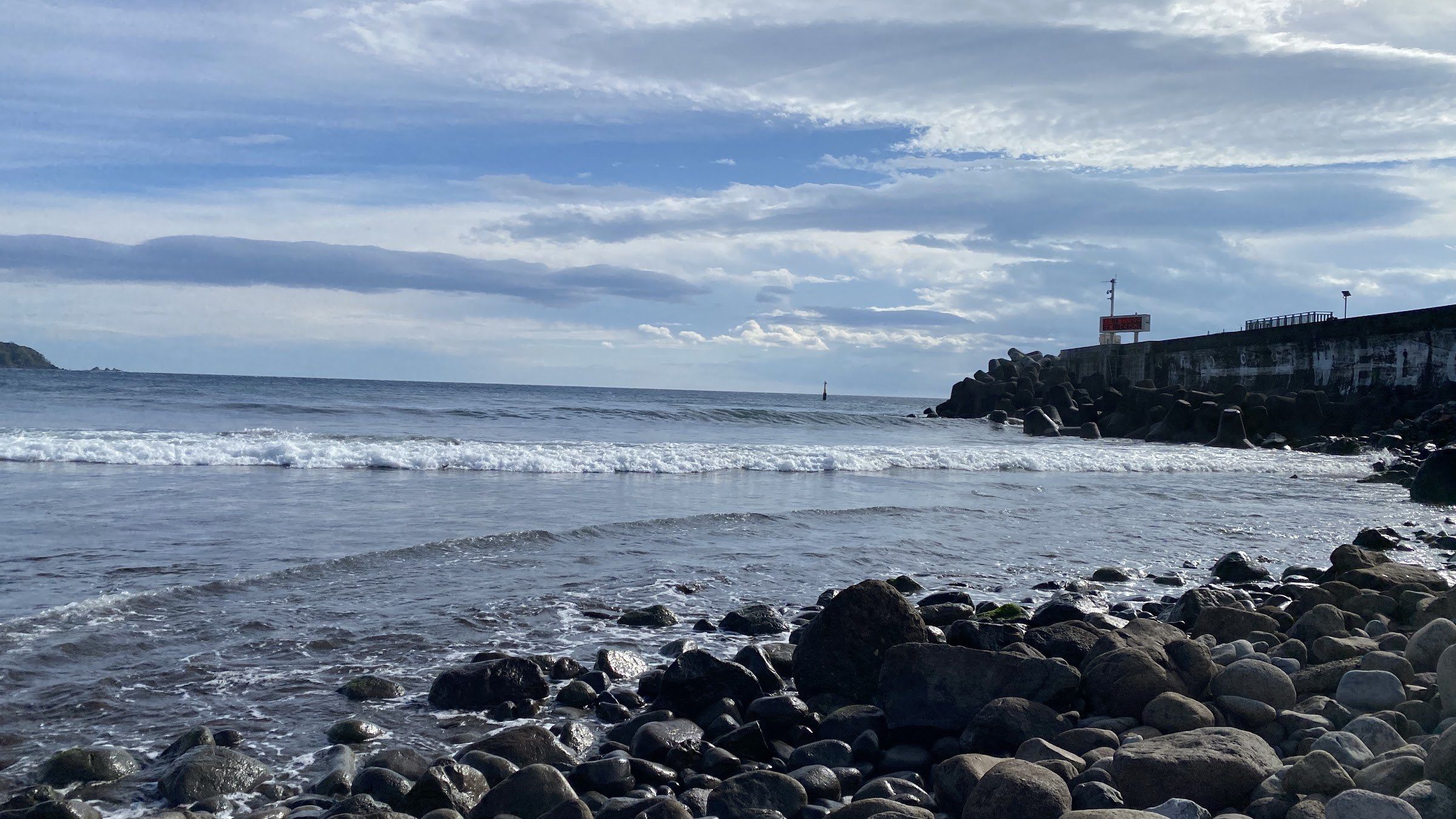 Waves reaching the rocky shoreline on Yugawara's coast