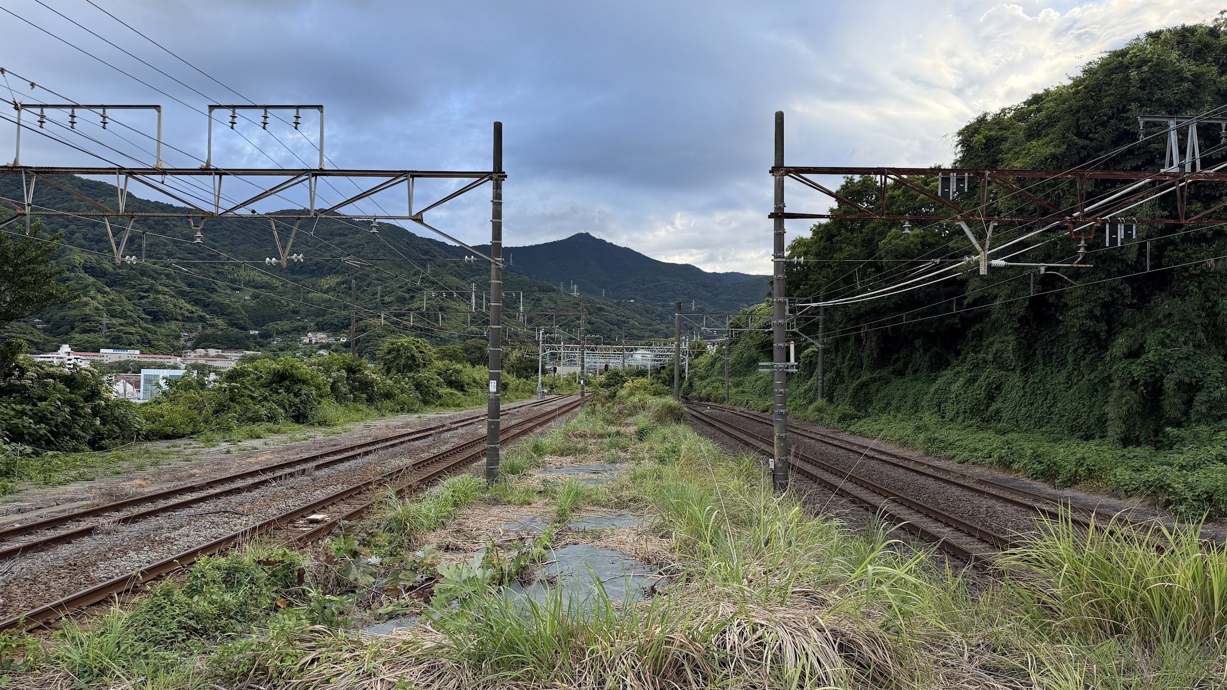Railway tracks passing between Yugawara's green hills