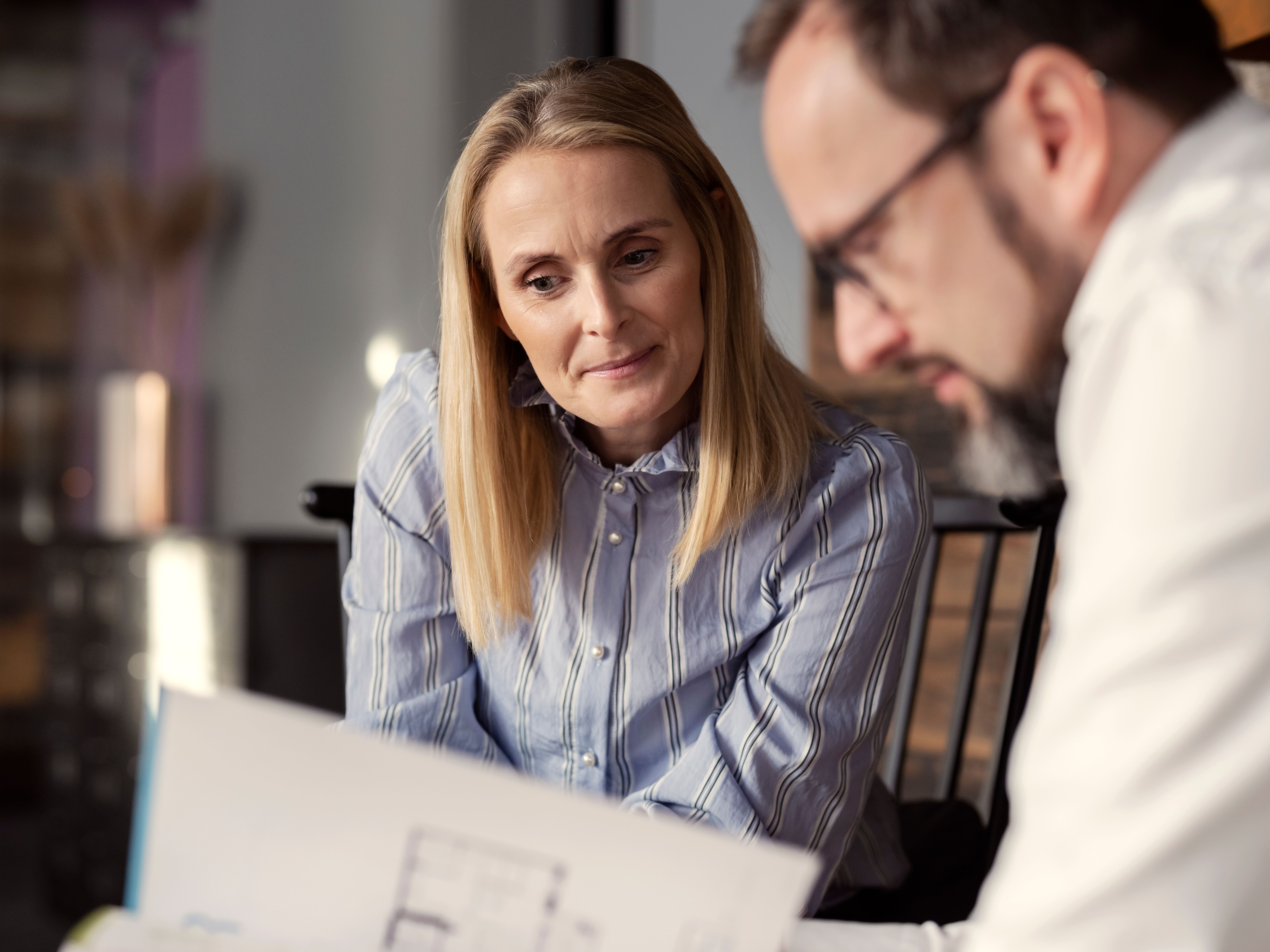 Kunde og megler ser på tilbud. Foto.