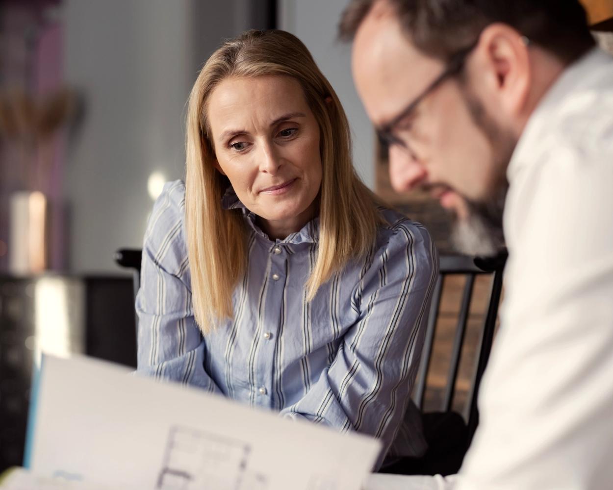 Kunde og megler ser på tilbud. Foto.