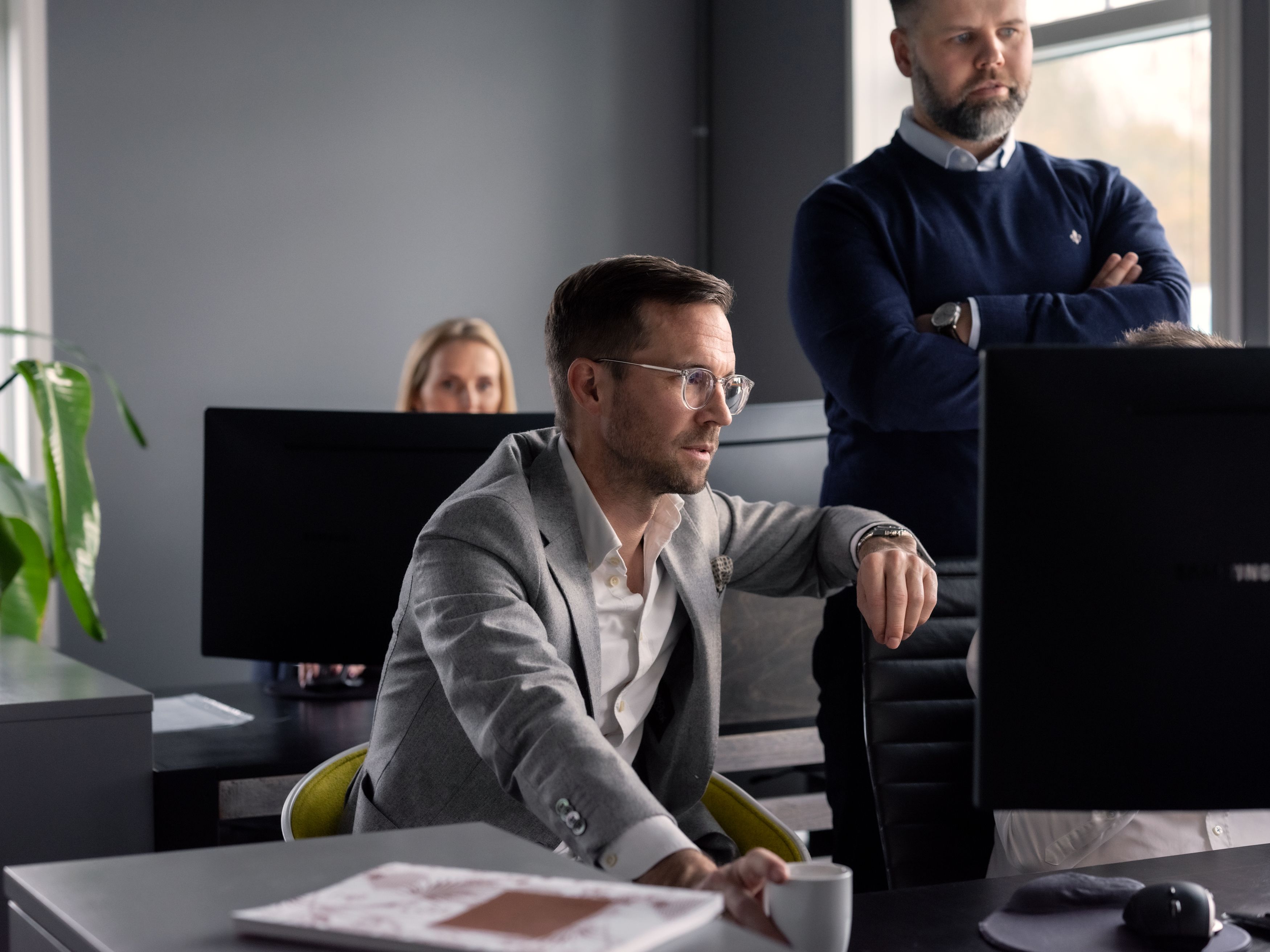 To eiendomsmeglere snakker sammen på rosa møterom. Foto.