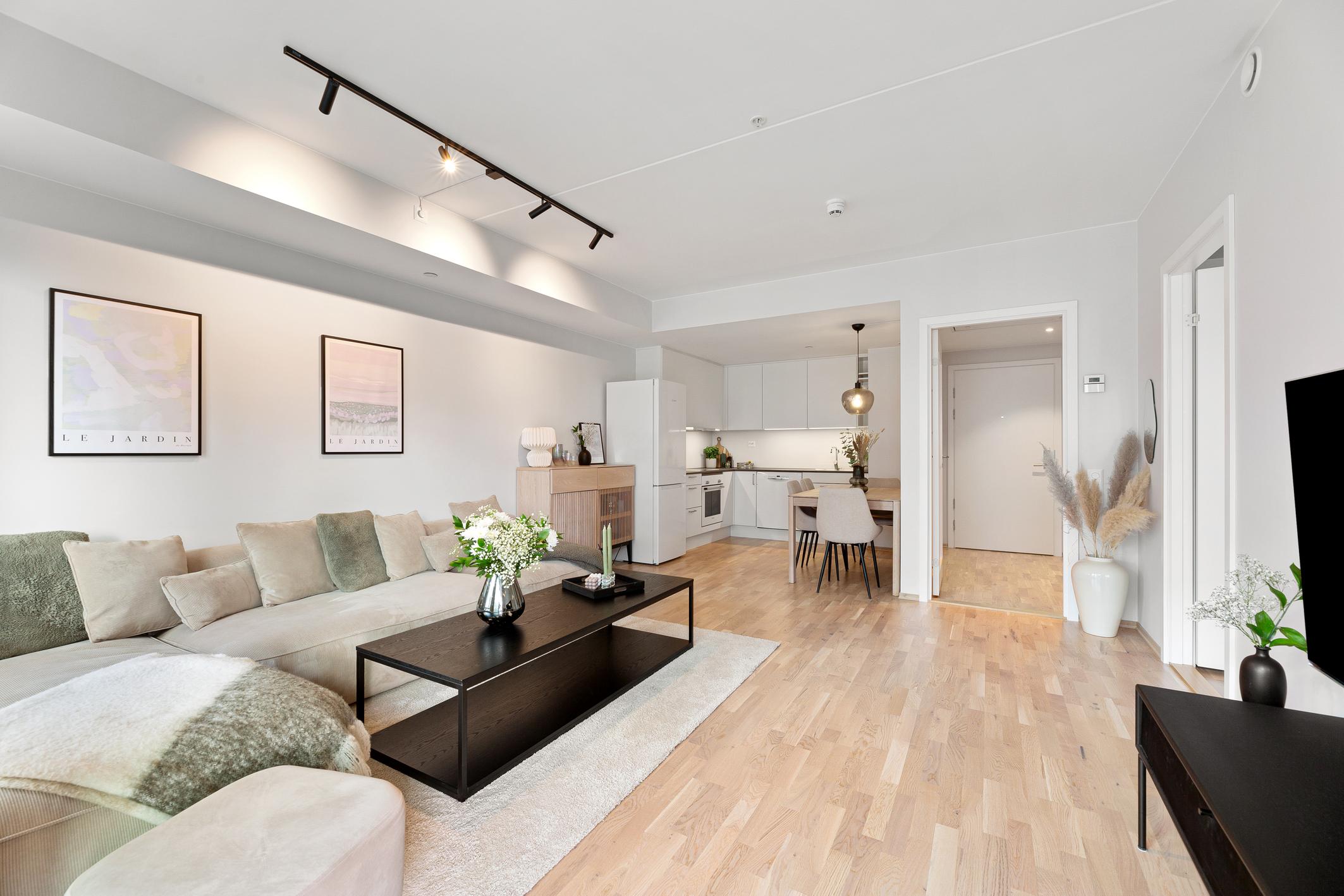 Lys og pen stue med åpen kjøkkenløsning