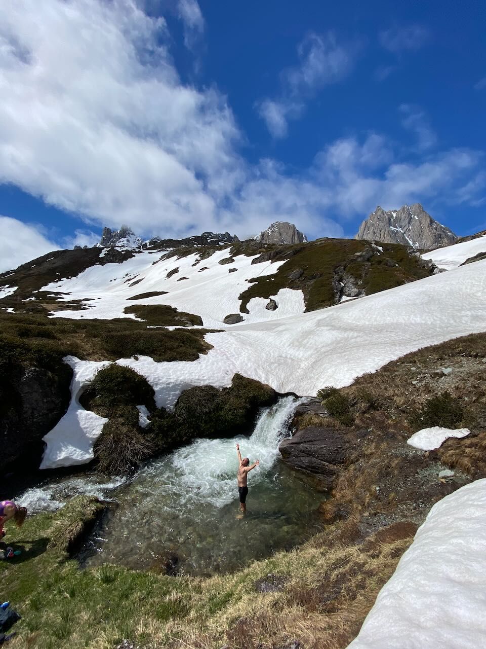 Photo of Ski Tourer enjoying a dip in an ice melt river after a spring ski tour