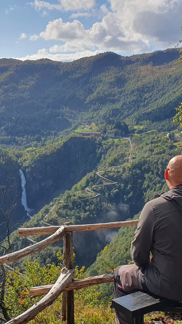 View of Stalheimsfossen from Gudvangen Spectacular view of Stalheimsfossen waterfall and Stalheim Hotel from a hiking path in Gudvangen, surrounded by dramatic mountains in Western Norway.