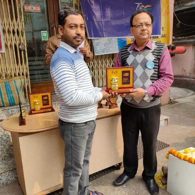 Samir Mondal receiving a recognition plaque from an LIC branch official