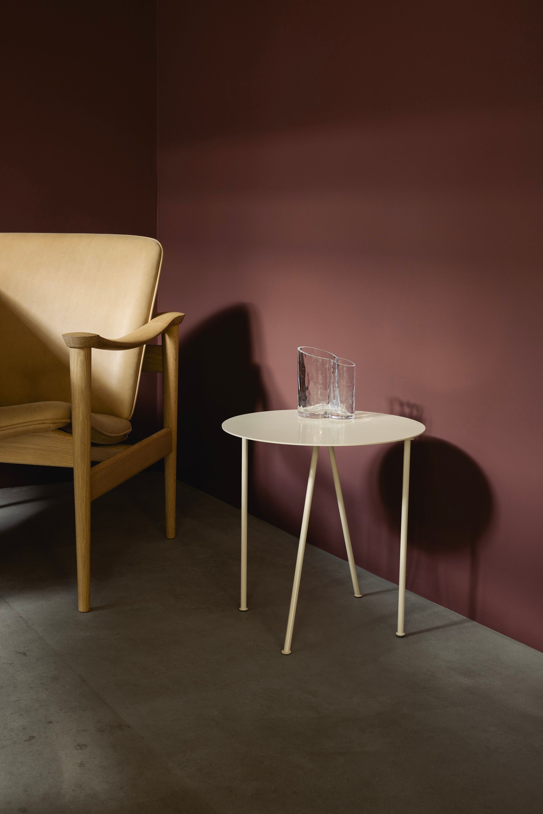 Round ivory coffee table next to aubergine walls