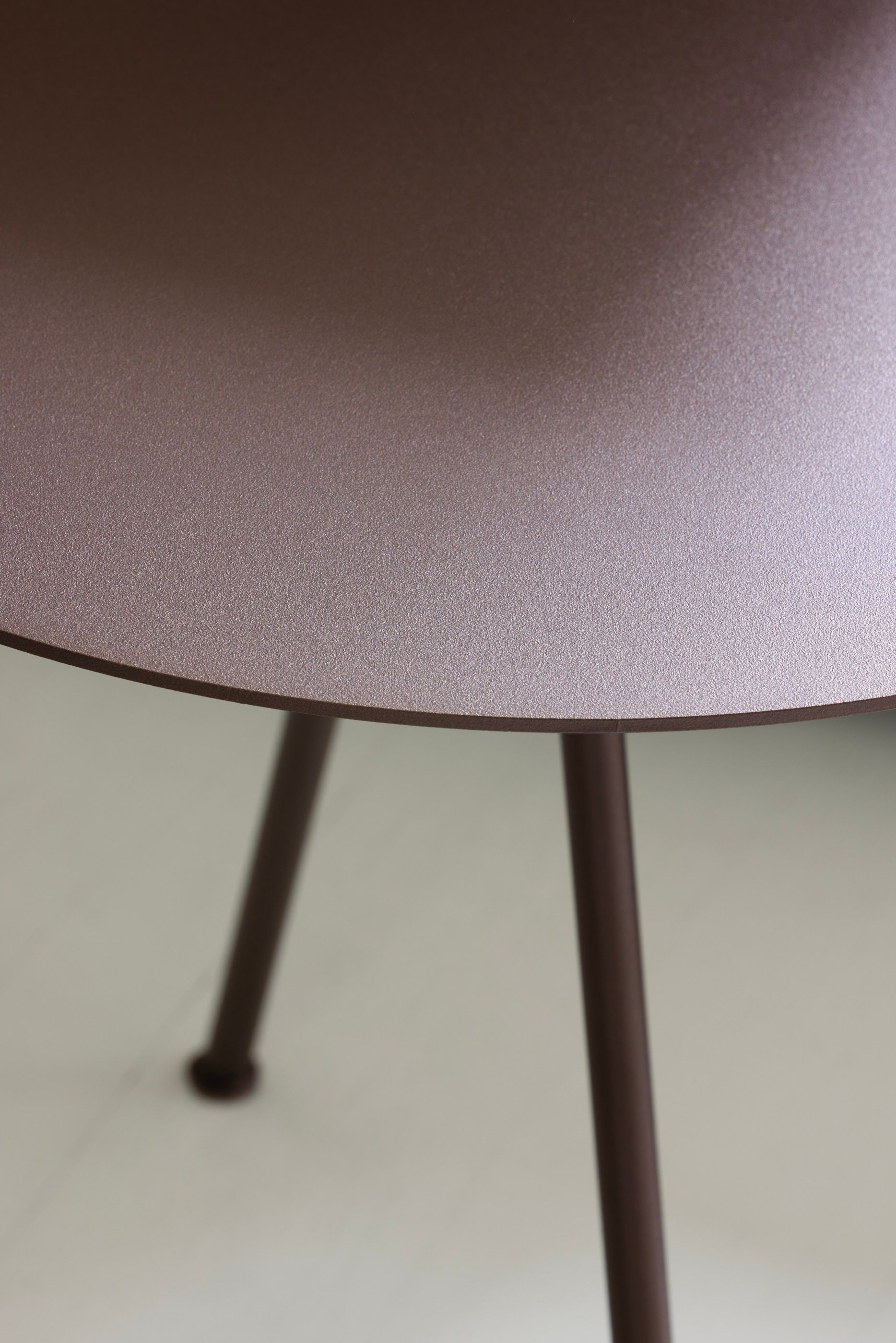 detail of bronze round coffee table with straight legs