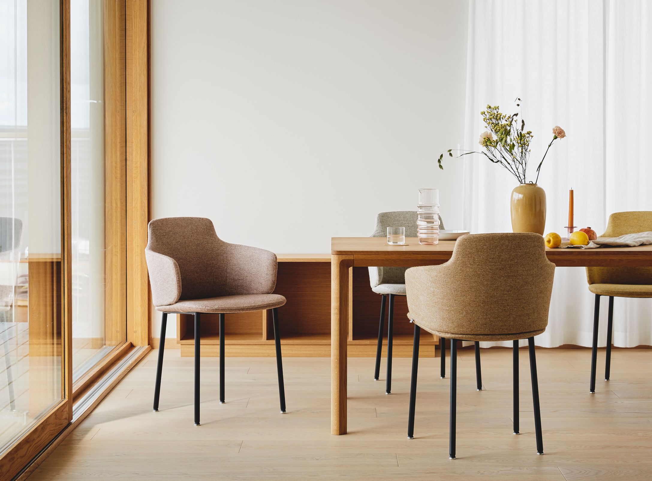 Ada chair by Jonas Stokke designed for LK Hjelle. Four chairs around a table designed by Jonas Stokke, The chair is upholstered and on four black steel legs.