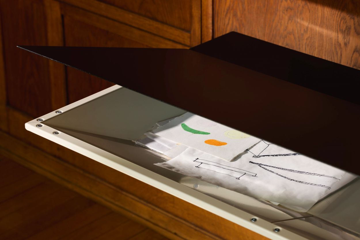 opened lid of a black and white console wiht drawings inside