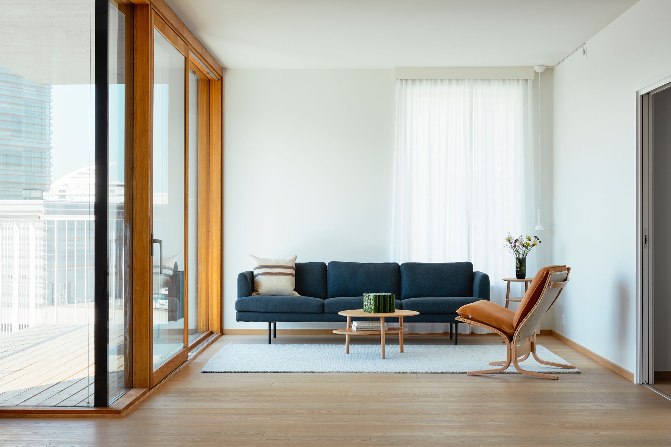 Sofa, wooden chair and lots of natural light from harbour apartment in Oslo