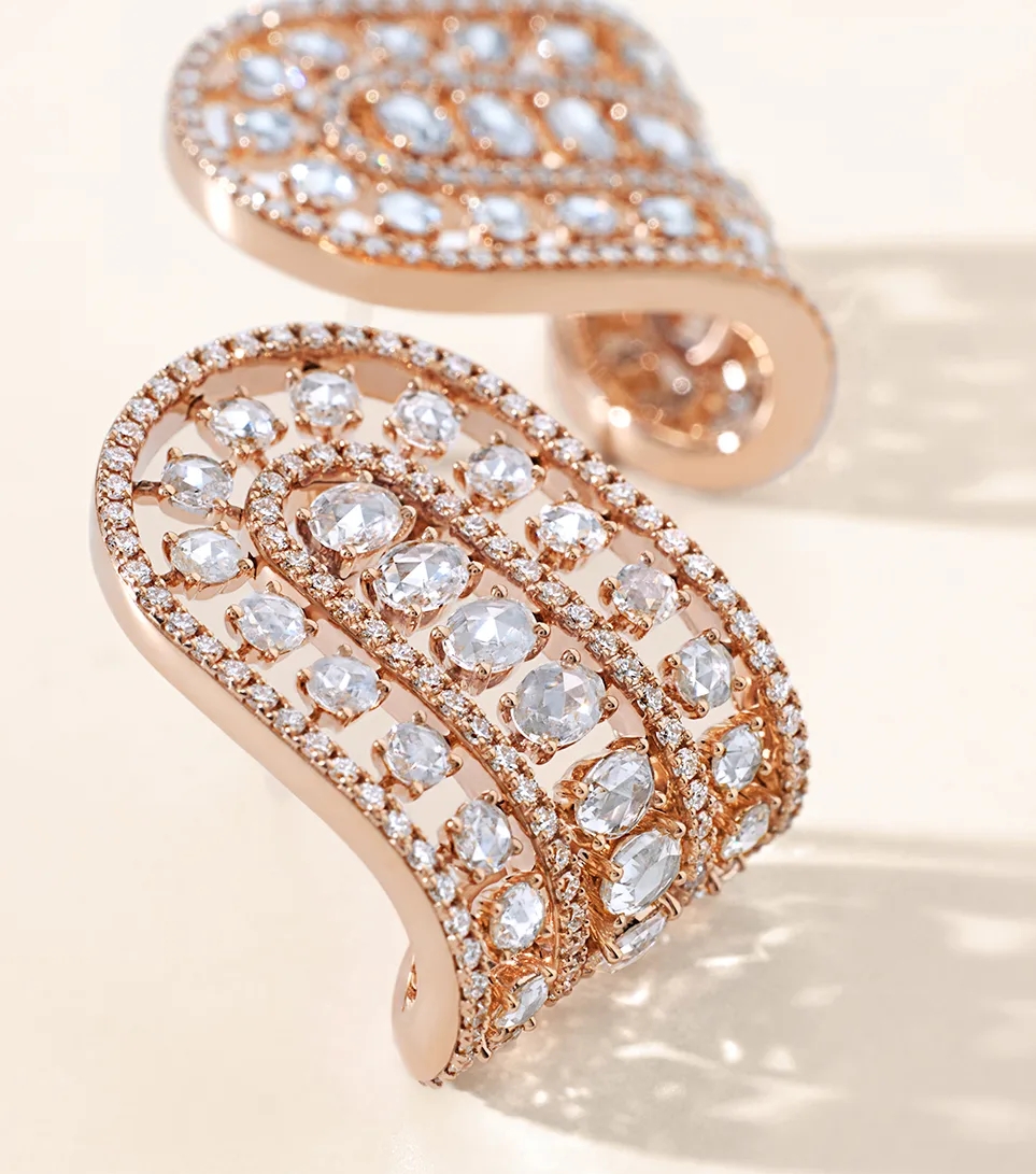 Woman wearing 18k rose gold and diamond earrings
