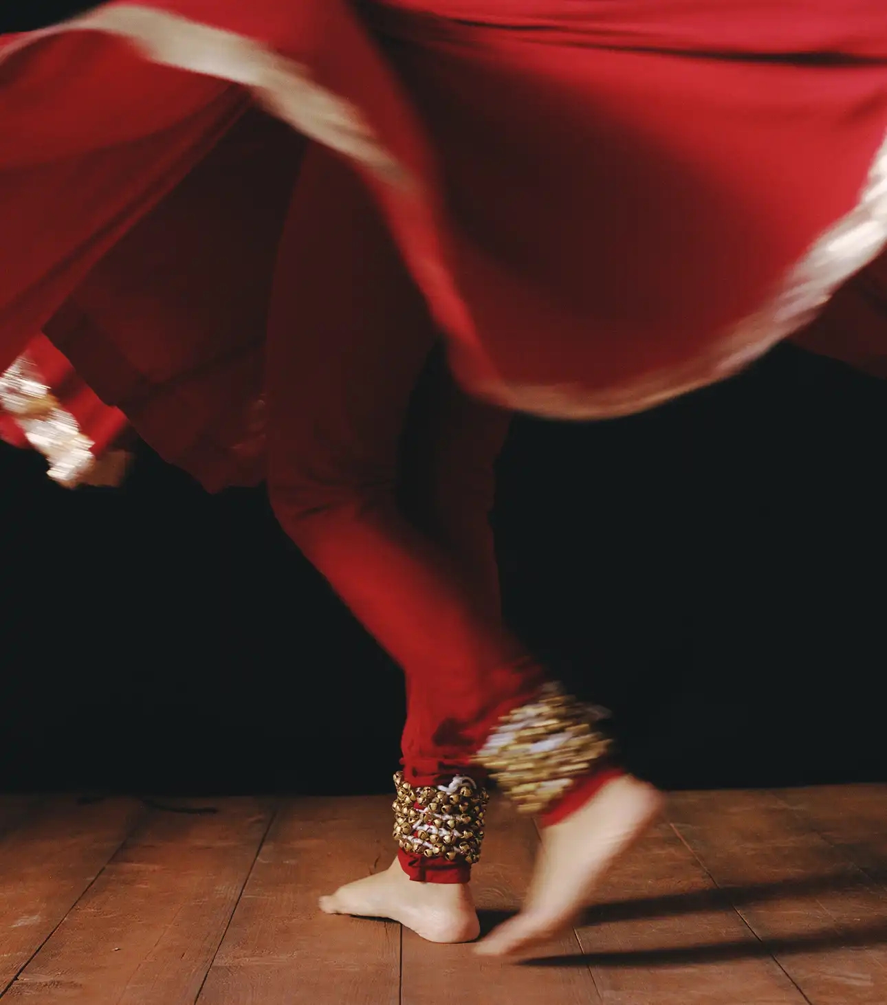 Woman in Indian traditional attire dancing with ghungroo