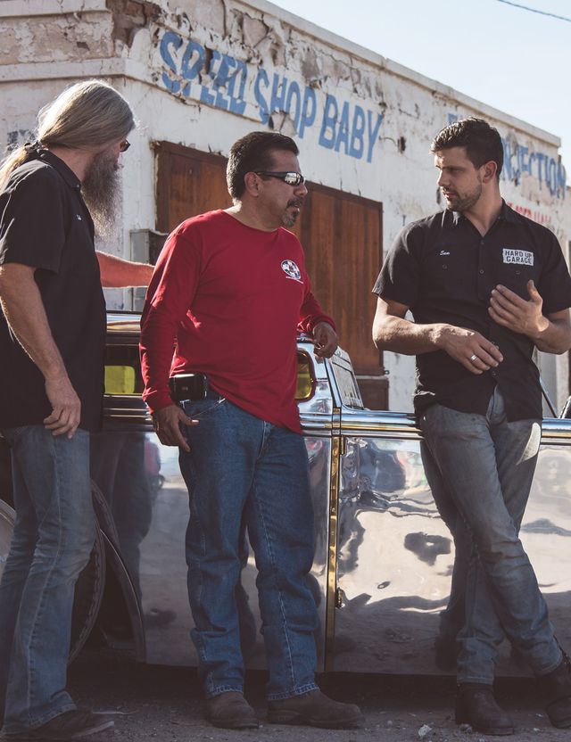 Three friends chatting outside a speed shop