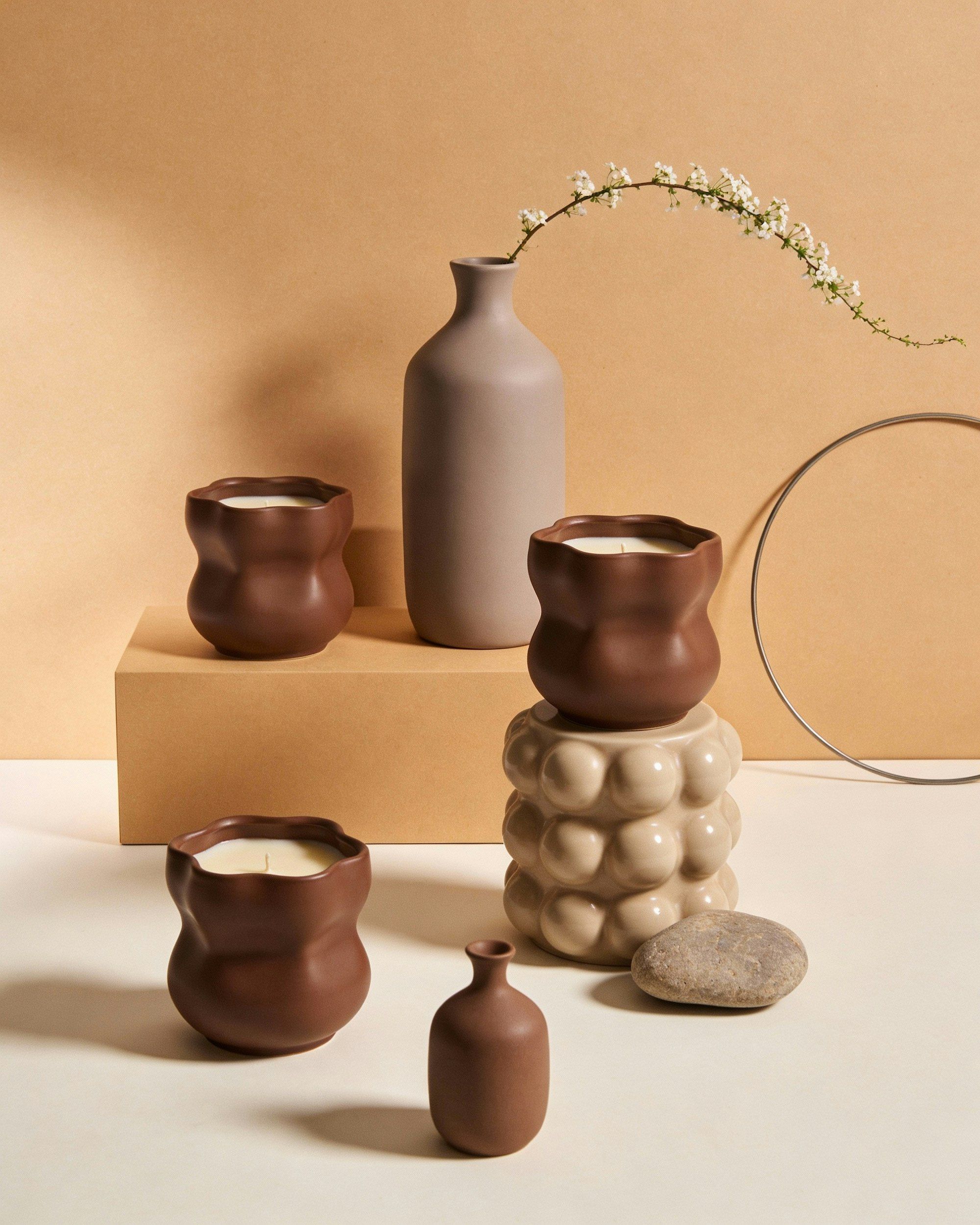 Clay vessels and books arranged on a warm shelf