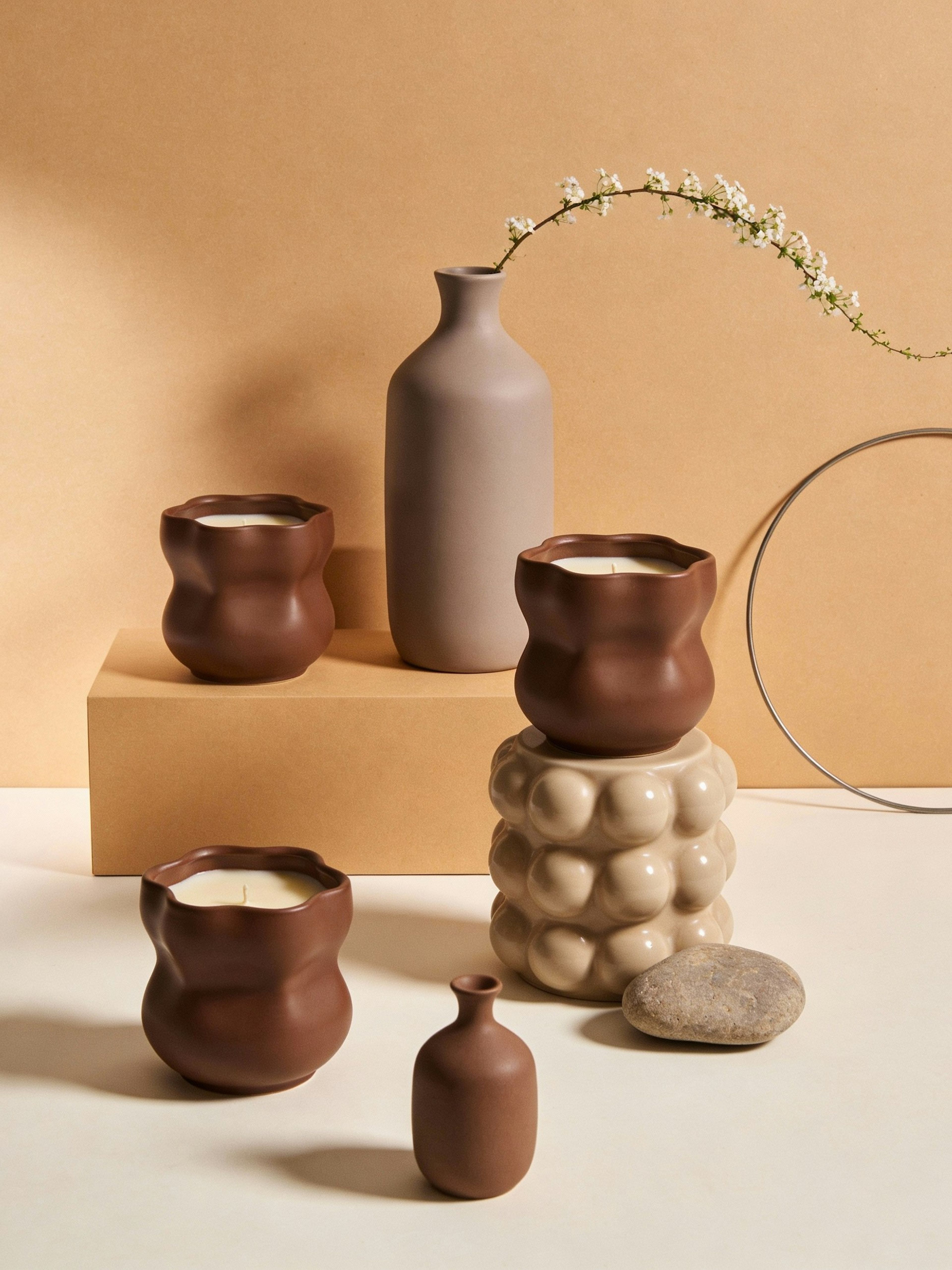 Clay vessels and books arranged on a warm shelf