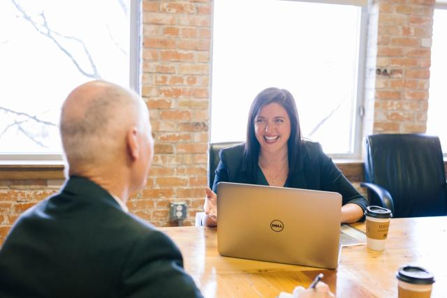Woman in front of laptop with man