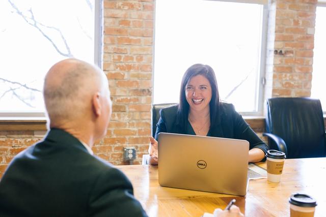 Woman in front of laptop with man
