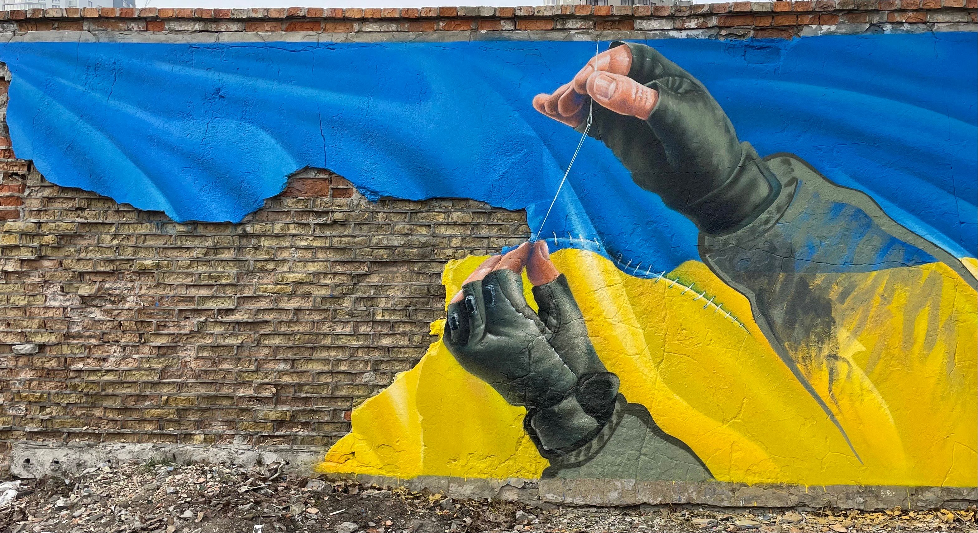 Gatekunst av et ukrainsk flagg som sys sammen.