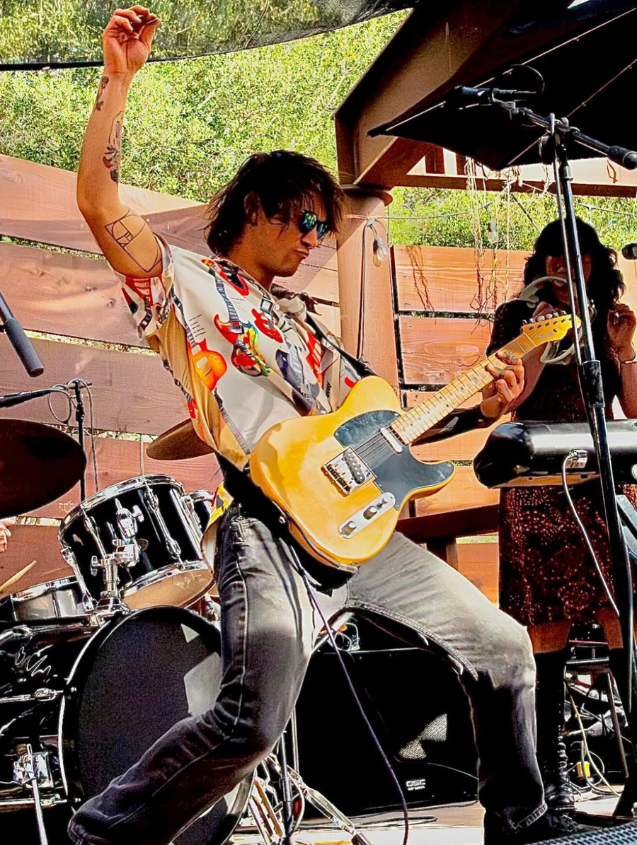 Hunter playing electric guitar mid-performance at an outdoor show.