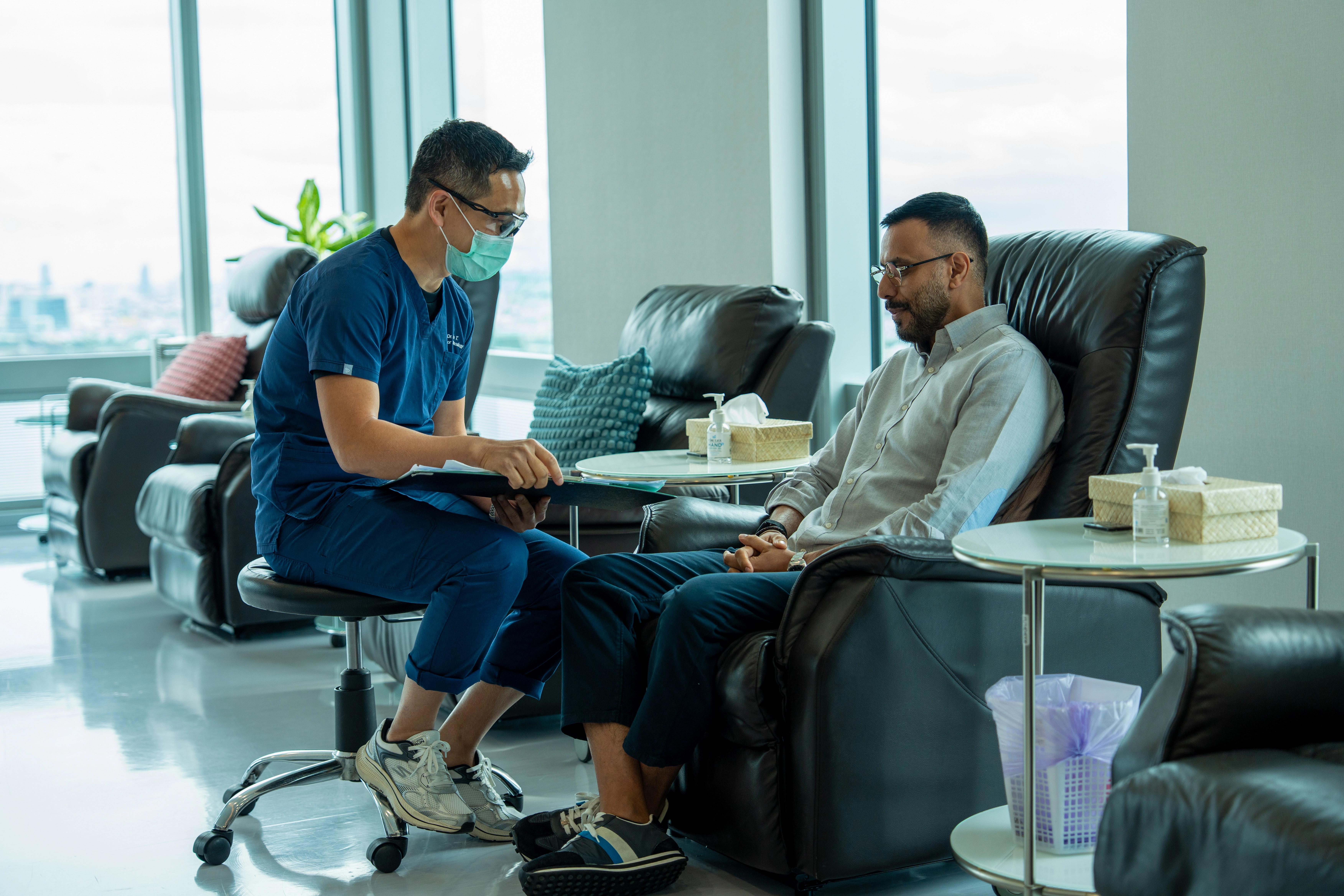 A Verita Life doctor talks with a patient in the clinic’s treatment lounge.