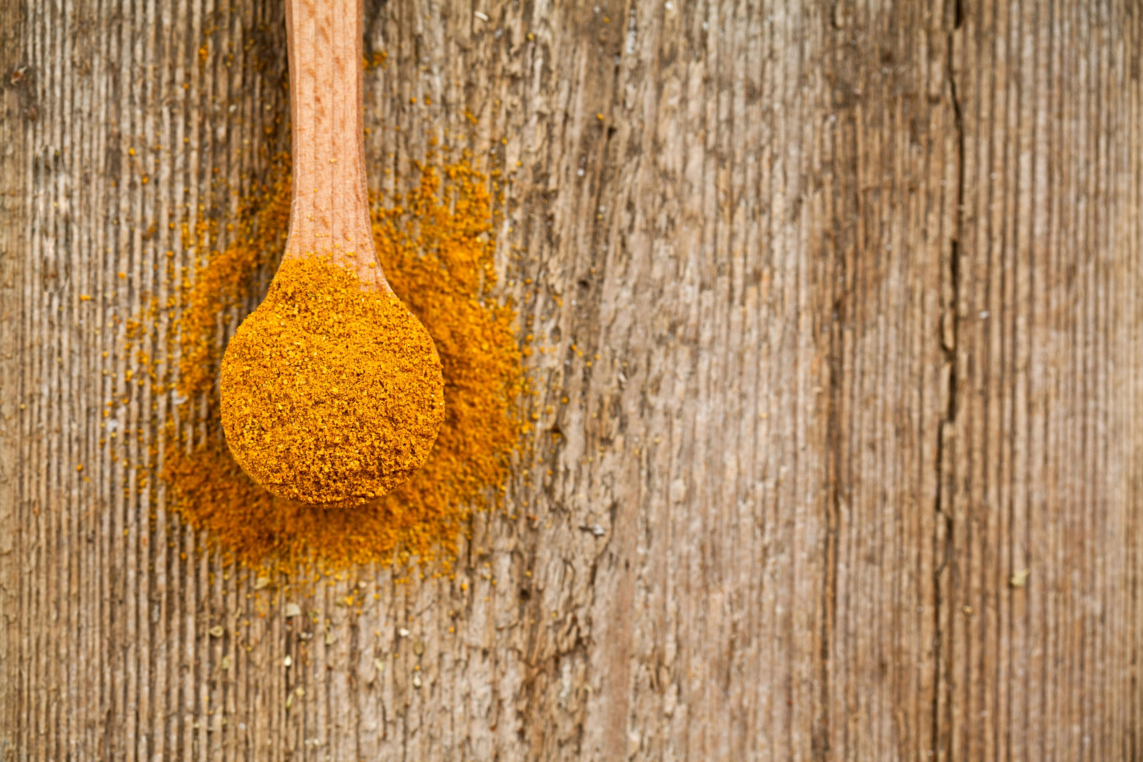 curcumin powder, derived from turmeric, displayed as a fine powder against a clean, neutral background.