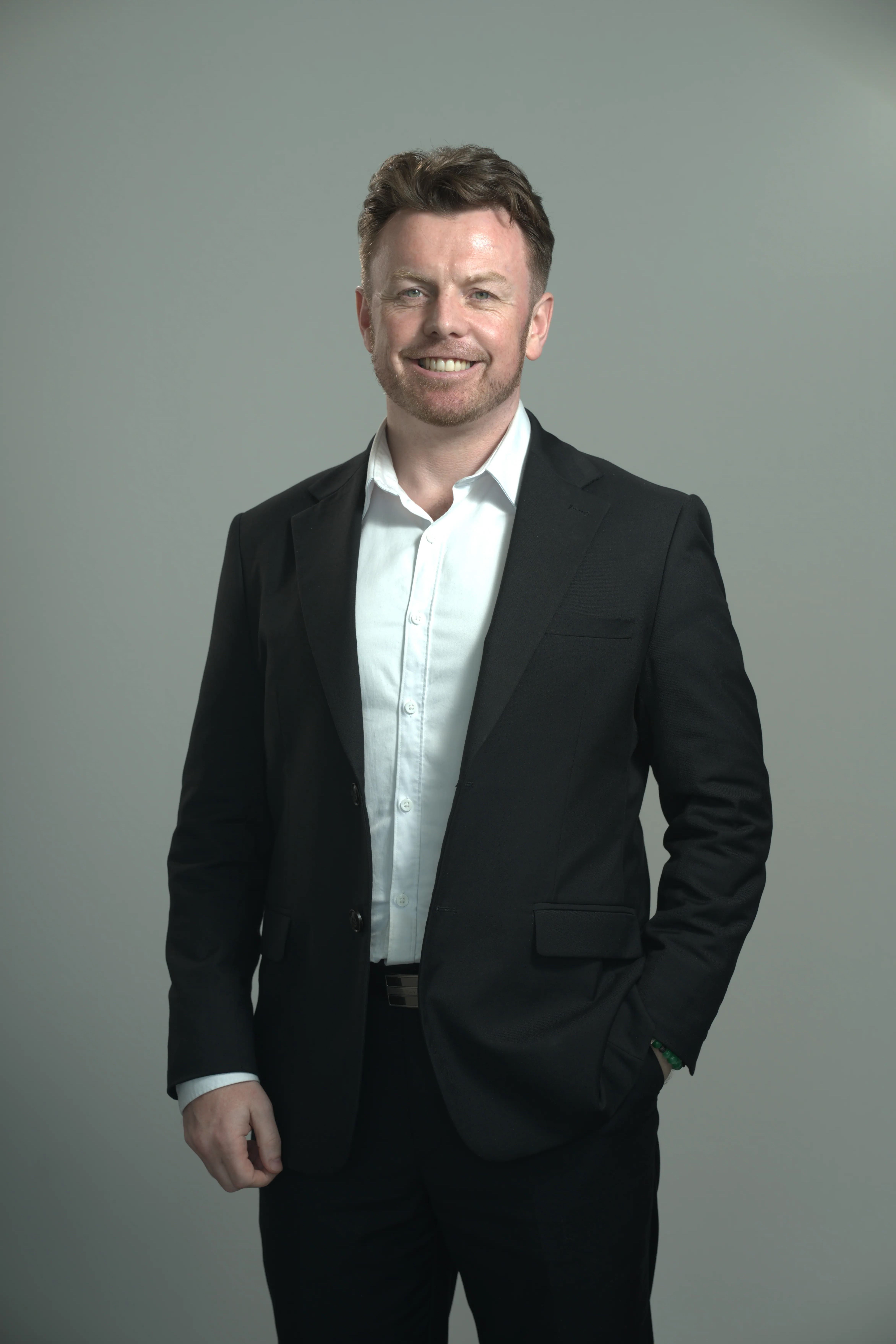 Smiling man in black suit and white shirt