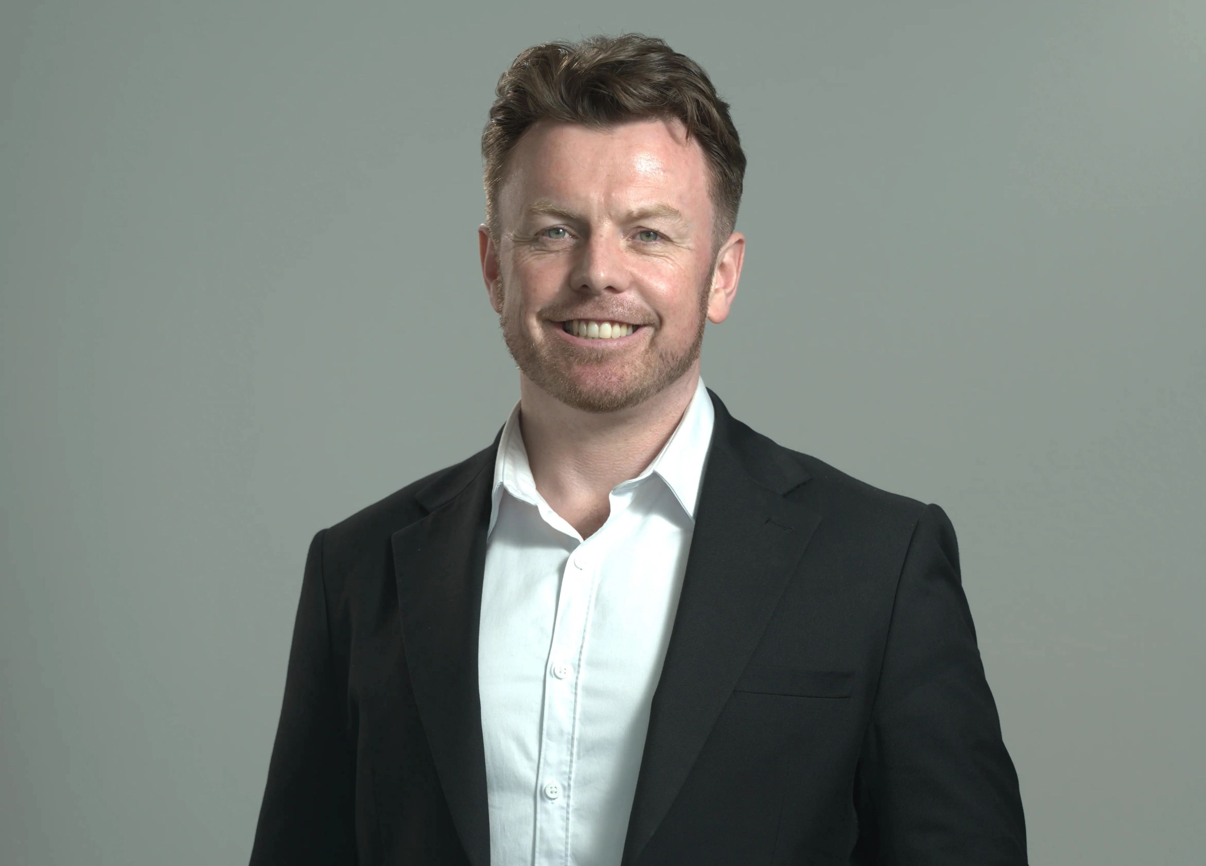 Smiling man in black suit and white shirt