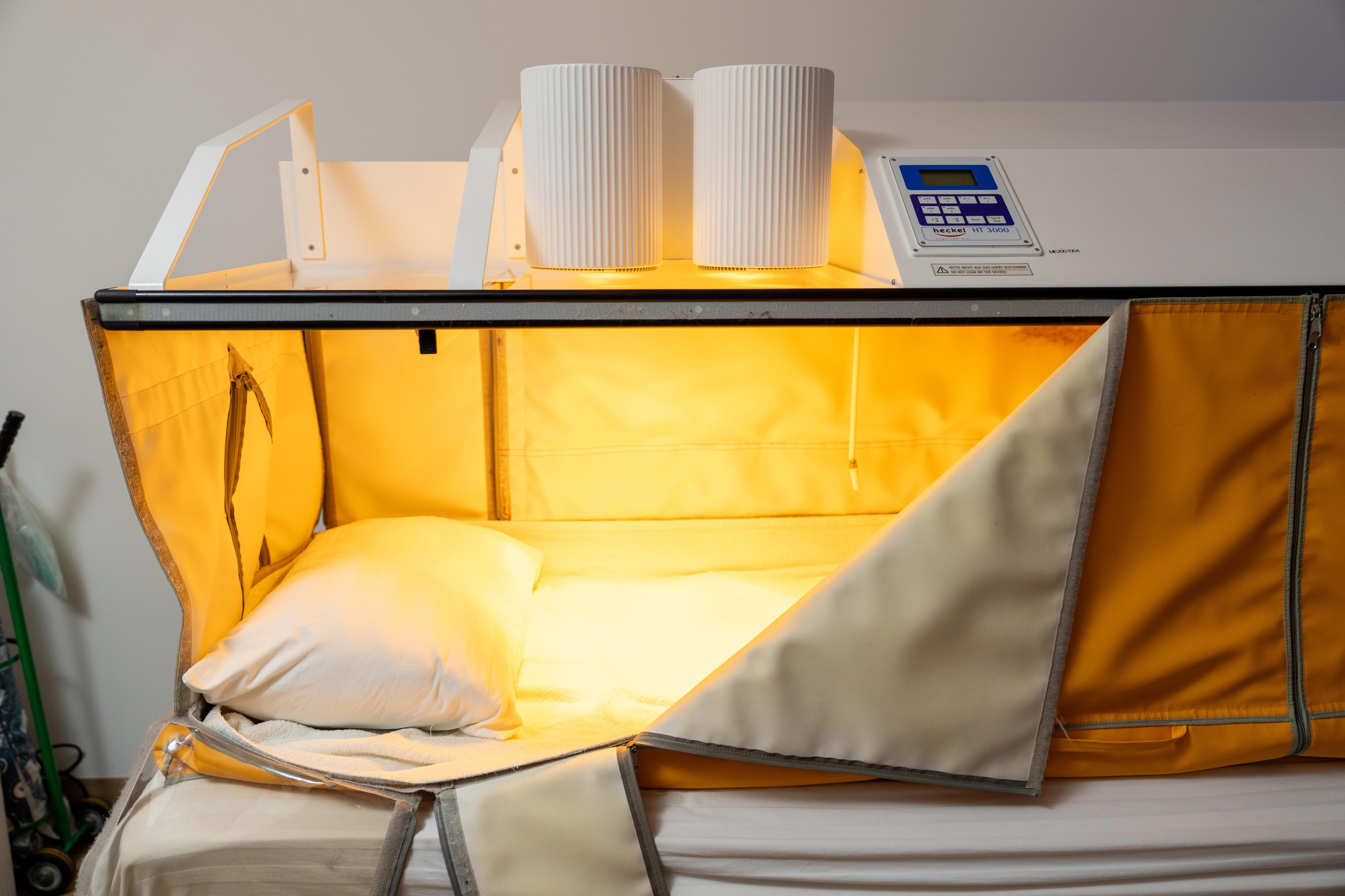 Whole-body hyperthermia treatment bed with an enclosed heating chamber