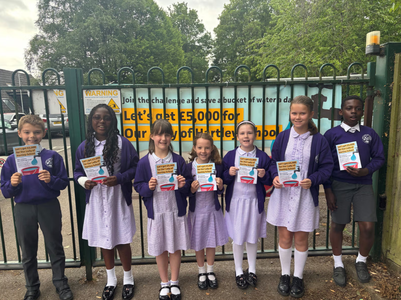 Students at Our Lady of Hartley School pose next to the water-saving challenges banner