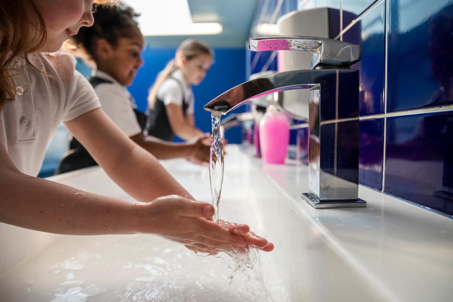 Children washing their hands under a running tap