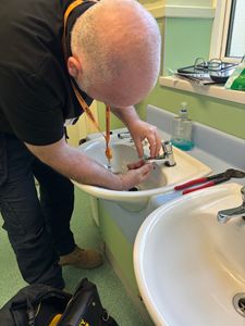 A South East Water plumber checks the taps in a bathroom as part of a water-saving visit