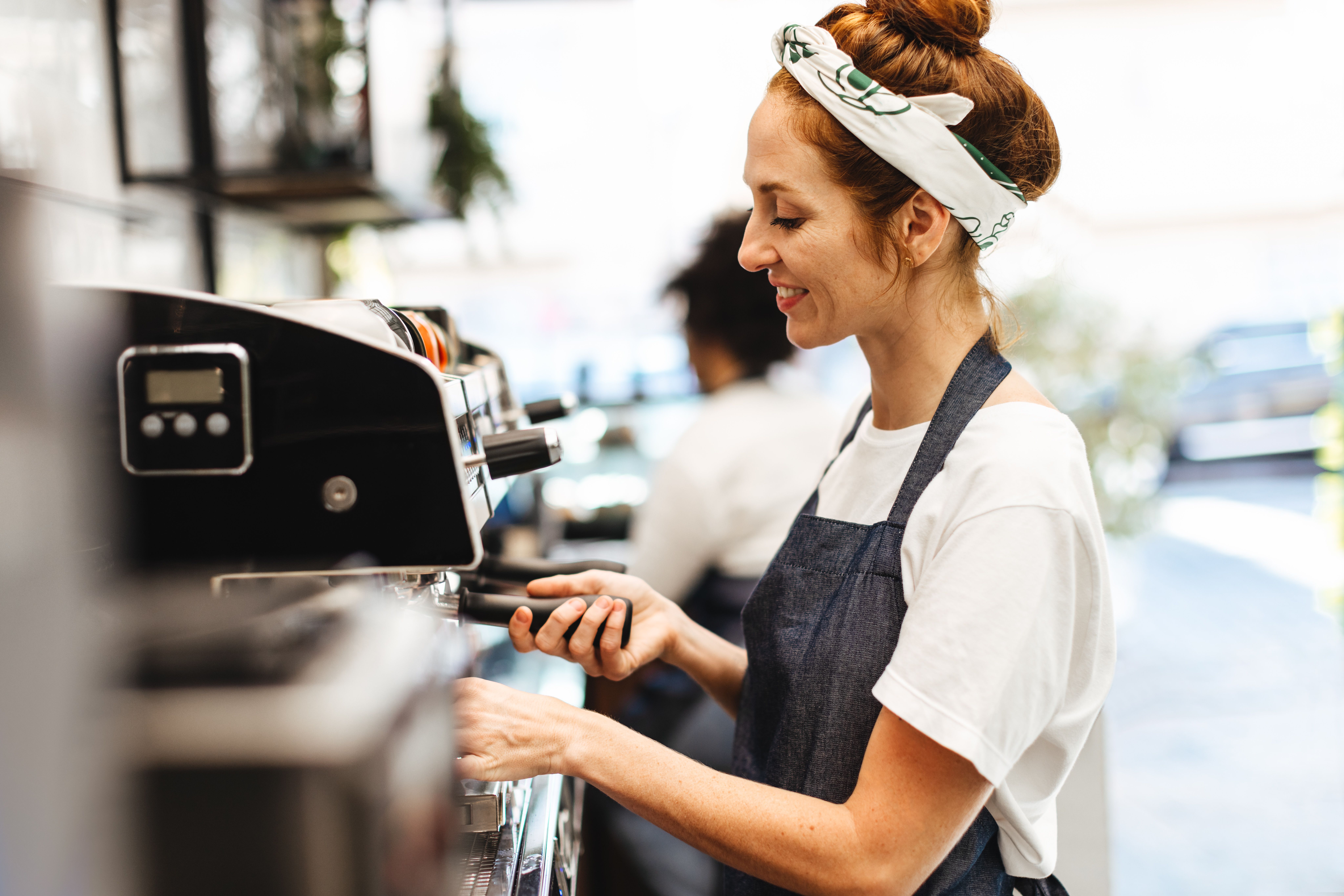 A barista in a cafe makes a hot drink