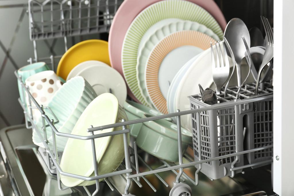 A fully-loaded dishwasher with cutlery and plates